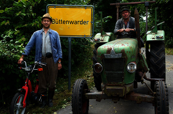 Neues aus Büttenwarder: Brakelmann (Peter Heinrich Brix) und Adsche (Jan Fedder) mit Ortsschild und Trecker. (Juni 2007). Bild: Sender / NDR / Sandra Höver, 