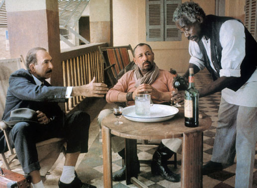 Lucien Cordier (Philippe Noiret, Mitte), Polizist in einem kleinen afrikanischen Ort, hat Besuch von dem Bruder (Jean-Pierre Marielle, li.) eines Mannes, den er umgebracht hat. Bild: Sender