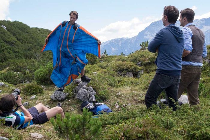 Im Wingsuit fühlt sich Fabian (David Rott) mittlerweile wohler als im Arztkittel. Für ein Fotoshooting mit dem Fotografen Plugg (Bastian Hagen) posiert er gekonnt, während sein Freund Sven (Michael Baral) und Sponsor Larry (Philippe Reinhardt) über einen Werbevertrag sprechen. Bild: Sender / ARD Degeto / Erika Hauri