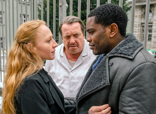 Zita (Brigitte Hobmeier) holt Alpha (Tony Harrisson Mpoudja, rechts) vor dem Gefängnis ab - Franz (Andreas Giebel) ist sauer. Bild: Sender/die film gmbh/Hendrik Heiden