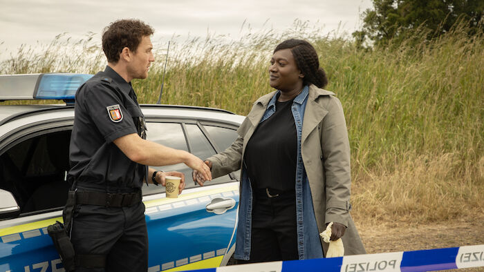 Die Polizistin und die Sprache des Todes: Pieper Olsen (Artjom Gilz) und Gloria Acheampong (Thelma Buabeng) treffen sich am Tatort. Bild: Sender / ZDF / Christine Schroeder