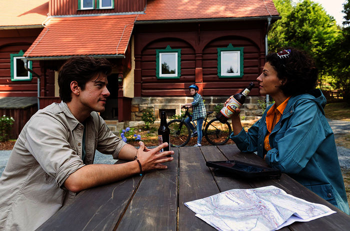 Vor der Rangerstation tauschen sich Ranger Jonas (Philipp Danne) und Biologin Emilia (Lisa Tzschirner) über eine mögliche Zukunft der Wölfe im Nationalpark aus. Bild: Sender / MDR / ndF / Tom Schulze