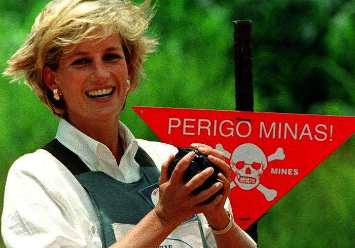 The Princess: Prinzessin Diana l&auml;chelt neben einem Warnschild in einer Bombenweste. Bild: Sender / ORF / NDR / Kent Gavin
