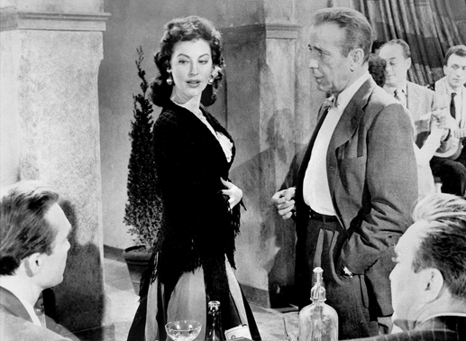 Regisseur Harry (Humphrey Bogart) soll für den schwerreichen Amerikaner Kirk (Warren Stevens) einen Film drehen. Für die Hauptrolle ist die Tänzerin Maria Vargas (Ava Gardner) vorgesehen. Bild: Sender