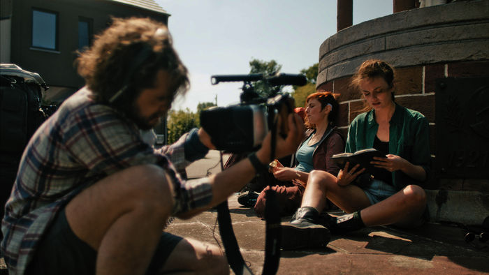 Ylena (Laurian Callebaut) und Zoë (Violet Braeckman) lesen auf ihrem Weg in Lisas Tagebuch. Michiel (Boris Van Severen) filmt die beiden Frauen dabei, um daraus eine Dokumentation zu produzieren. Bild: Sender / ZDF / Sofie Gheysens