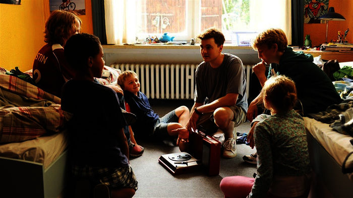 Auf Augenhöhe. Michi (Luis Vorbach) und Erzieher Chris (Phil Laude) mit den anderen Heimkindern. Bild: ZDF/KiKA/ Tobis Film / Kerstin Stelter