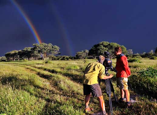 Schauplatz der 40-teilige Dokuserie ist die Tierrettungsstation "Harnas" am Rand der afrikanischen Kalahari-Wüste . Kameramann Harald Mittermüller und Assistent Roland Mittermüller beim Dreh - Landschaft mit doppeltem Regenbogen. Bild: Sender