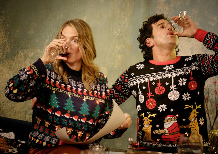 Zwei Weihnachtsmänner sind einer zu viel: Da hilft nur noch ein Glas Rotwein auf Ex: Das Paar Karo (Marie Burchard) und Lasse (Serkan Kaya) hat sich mit der Situation arrangiert. Die Eltern der beiden haben die Gestaltung des Weihnachtsfests erfolgreich übernommen. Bild: Sender / ZDF / Nik Konietzny