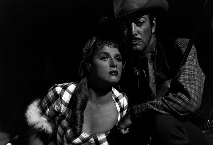 Fifi Danon (Denise Darcel) und Buck Wyatt (Robert Taylor) werden ein Paar, auch wenn Buck zunächst kein Interesse zeigt. Bild: Sender / Warner Bros. Entertainment Inc.